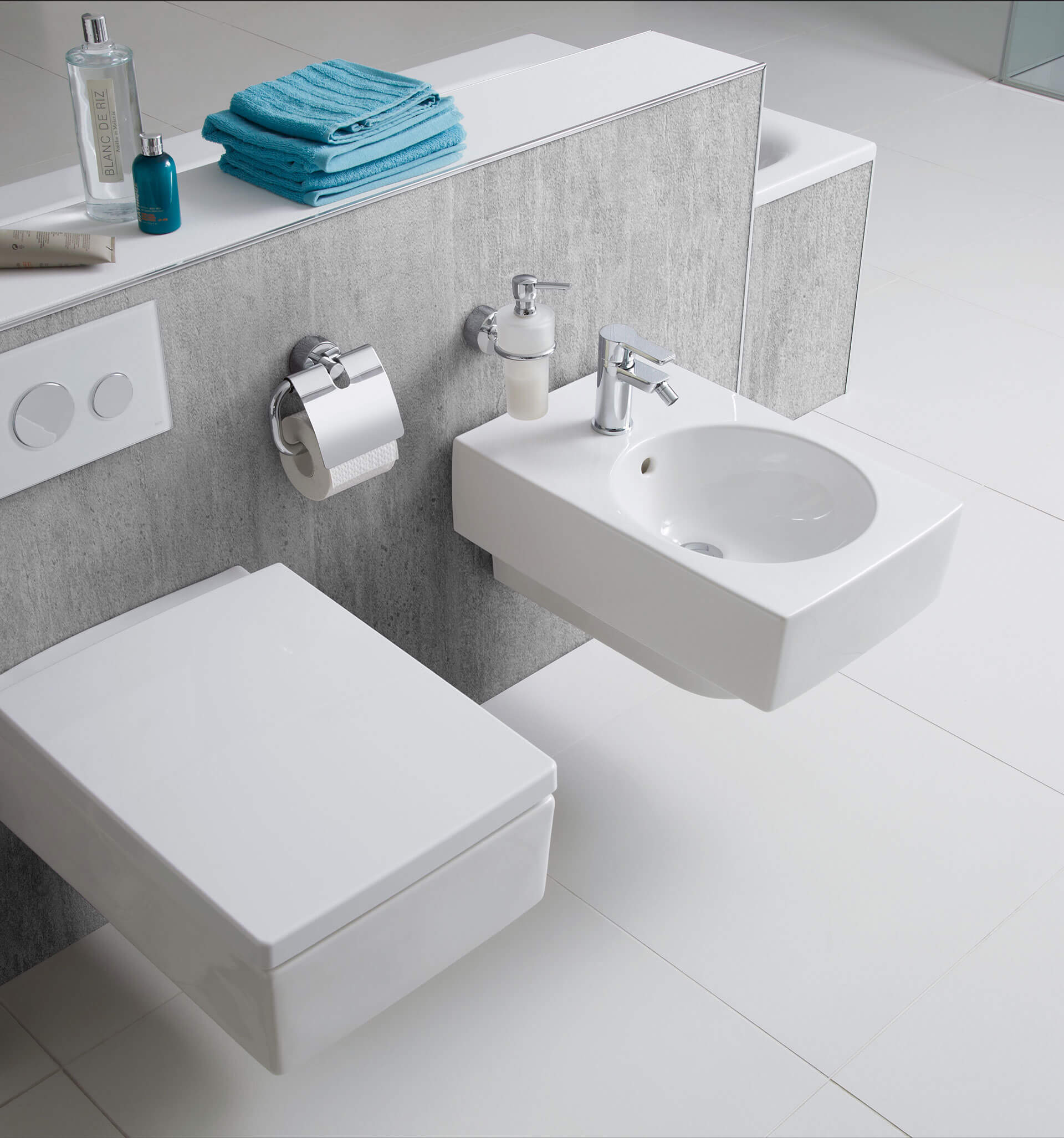 Weißes Wand-WC und freihängendes weißes Waschbecken an grauer Wand
