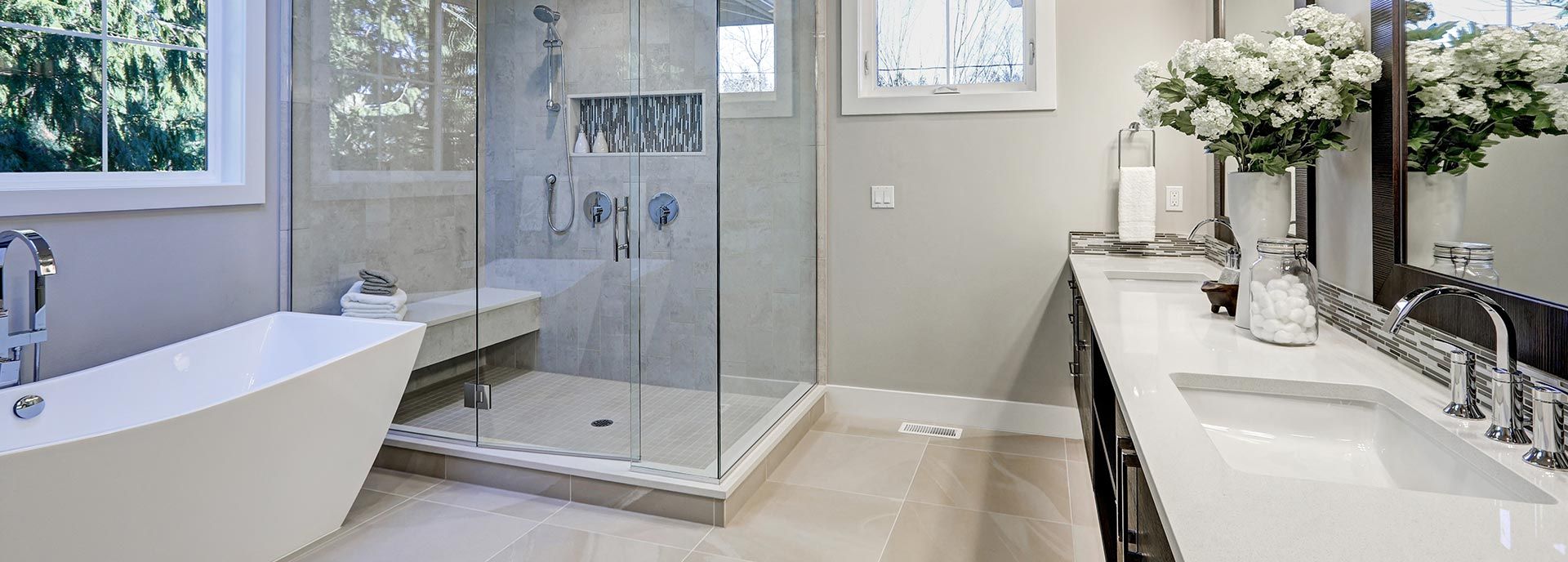 Badezimmer die Spaß machen Foto von einem modernen Bad mit freistehender Badewanne, bodengleiche Dusche mit Sitzbank und einem Doppelwaschtisch