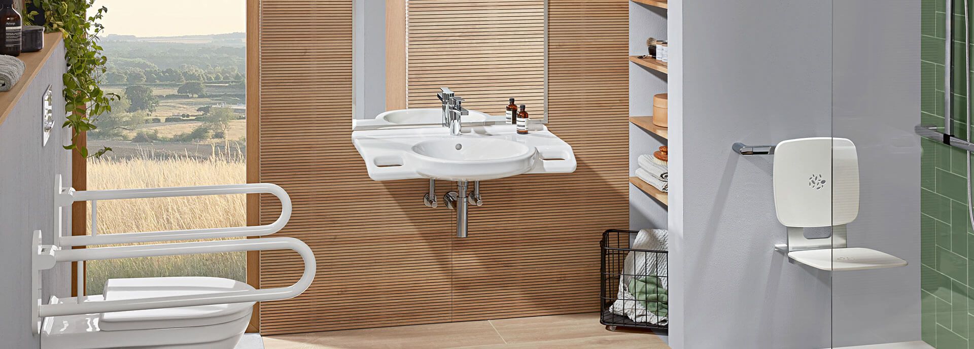 Barrierefreies Bad mit WC, Waschtisch, Haltegriffen und klappbarem Duschsitz.