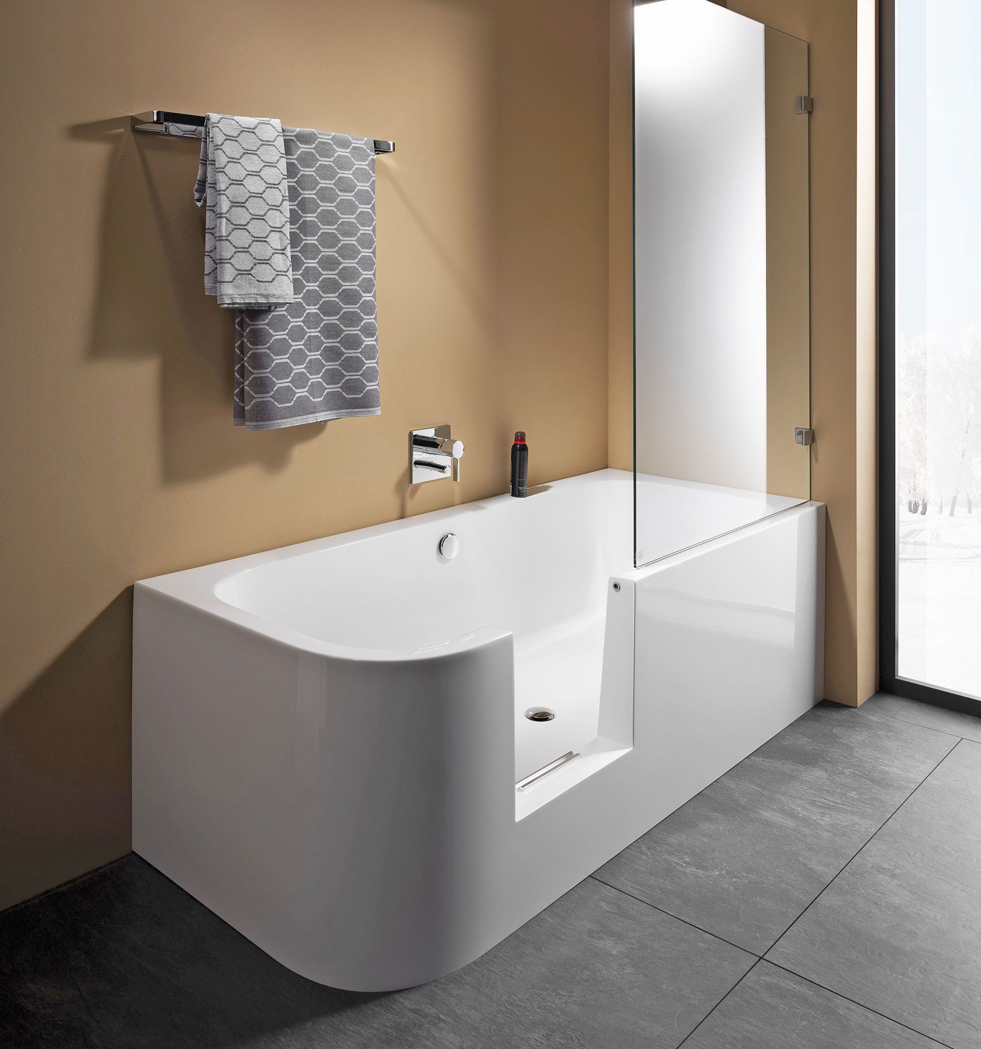 Moderne Badewanne mit niedriger Einstiegsöffnung und Glasduschabtrennung.