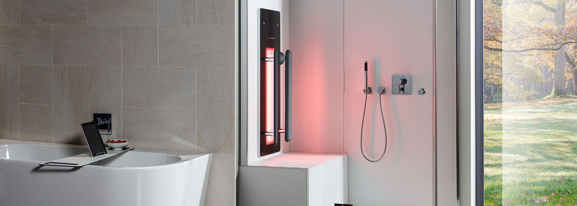 Moderne Dusche mit Infrarot-Paneel, freistehende Badewanne und große Fensterfront mit Blick ins Grüne.