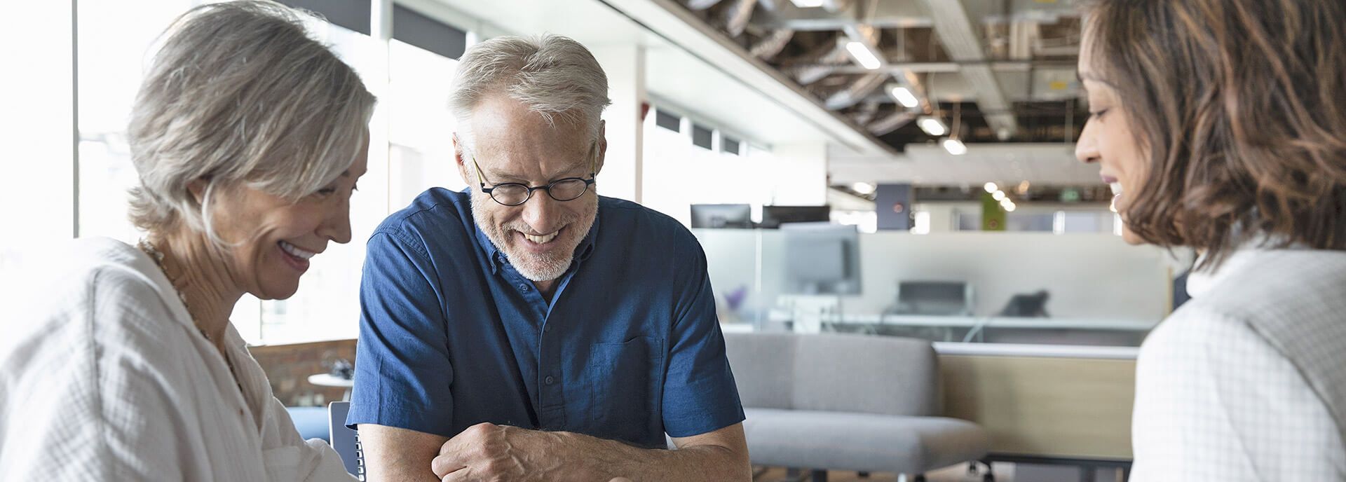 Beratung vom Profi Zwei lächelnde Menschen im Gespräch mit einer Beraterin.