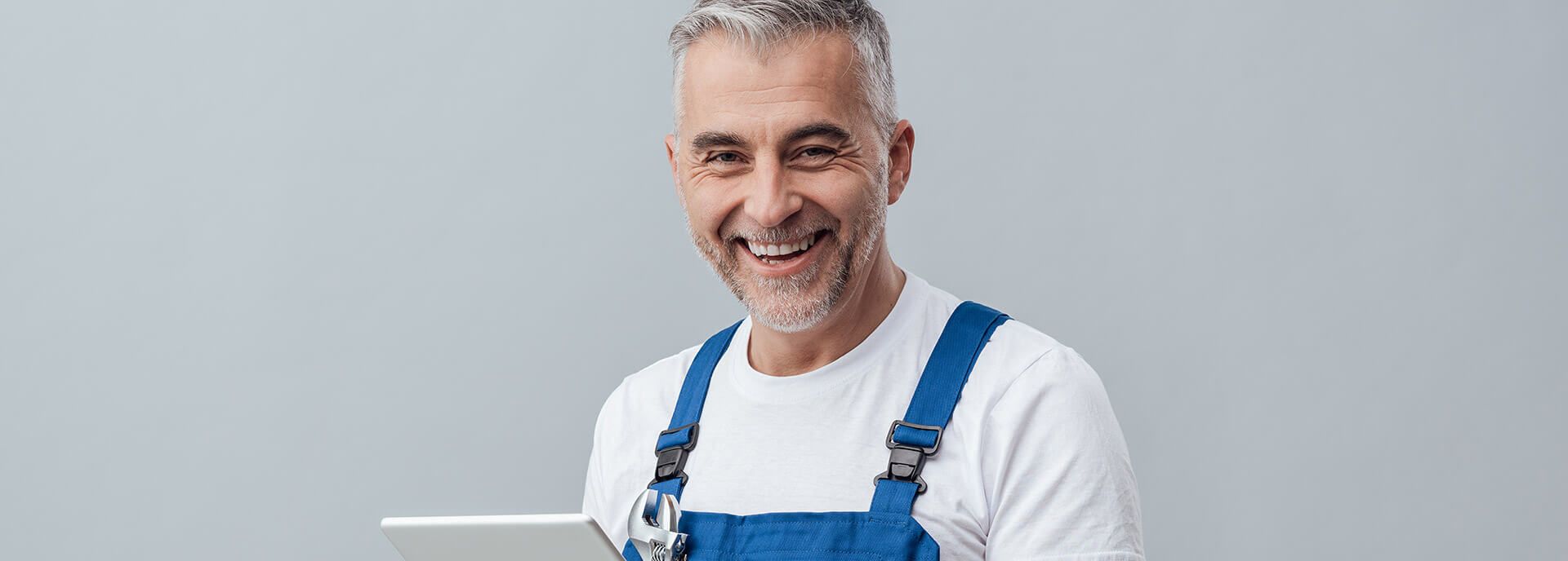 Lächelnder Mann mit Latzhose und weißem T-Shirt